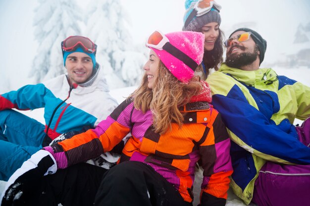 Dos parejas divirtiéndose y haciendo snowboard.