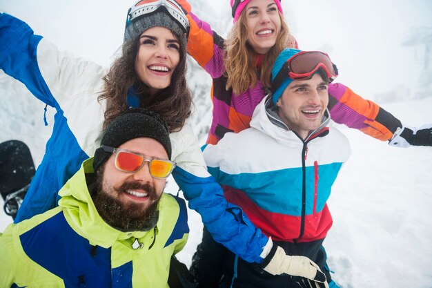 Dos parejas divirtiéndose y haciendo snowboard.