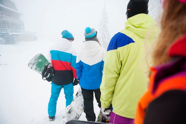 Dos parejas divirtiéndose y haciendo snowboard.