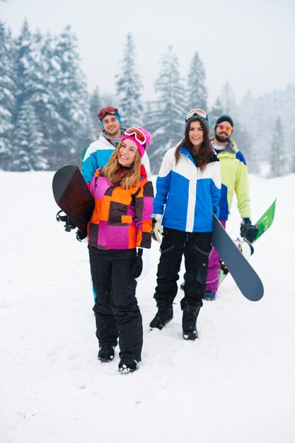 Dos parejas divirtiéndose y haciendo snowboard.