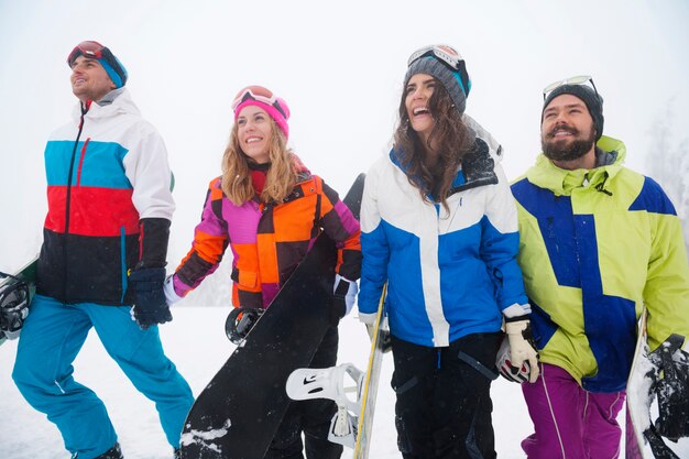 Dos parejas divirtiéndose y haciendo snowboard.