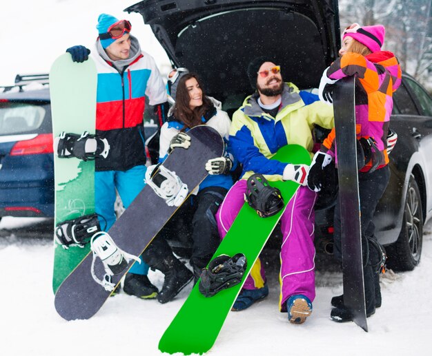 Dos parejas divirtiéndose y haciendo snowboard.