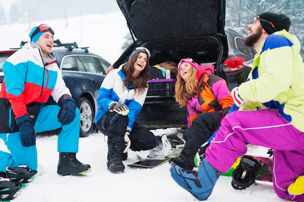 Dos parejas divirtiéndose y haciendo snowboard.