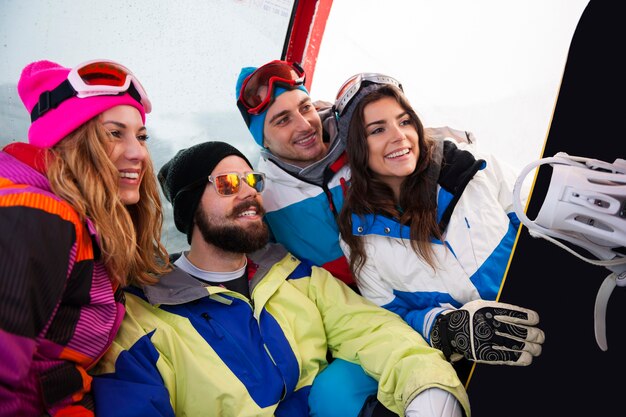 Dos parejas divirtiéndose y haciendo snowboard.