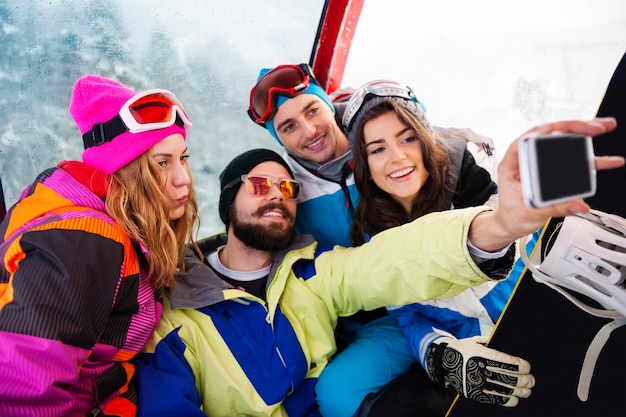 Dos parejas divirtiéndose y haciendo snowboard.