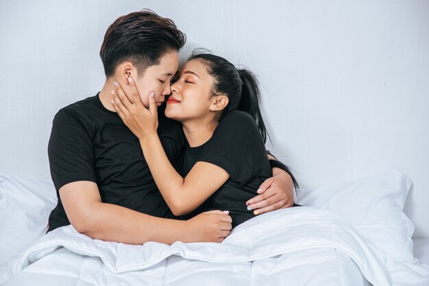 Dos parejas de mujeres abrazados juntos en la cama.