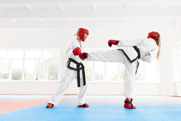 Foto gratuita dos peleas profesionales de karate usando la técnica de karate patada y puñetazo