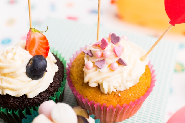 Dos pequeños cupcakes con bayas en mesa