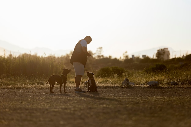 Dos perros al aire libre entrenados por un entrenador masculino