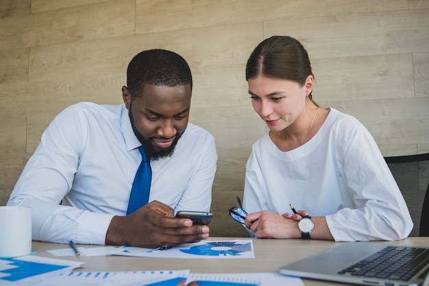 Foto gratuita dos personas de negocios mirando al smartphone