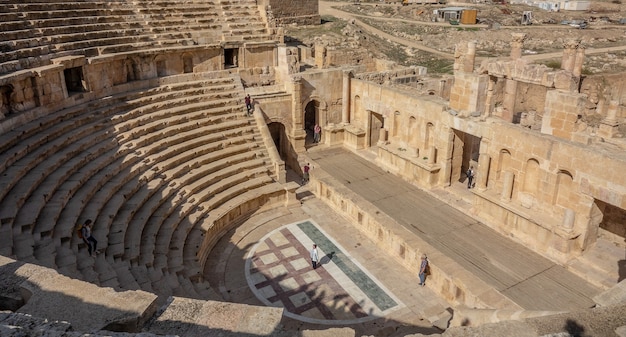 Dos personas de pie en un antiguo anfiteatro durante el día