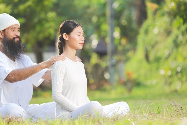 Dos personas en traje blanco haciendo masaje con emoción relajante