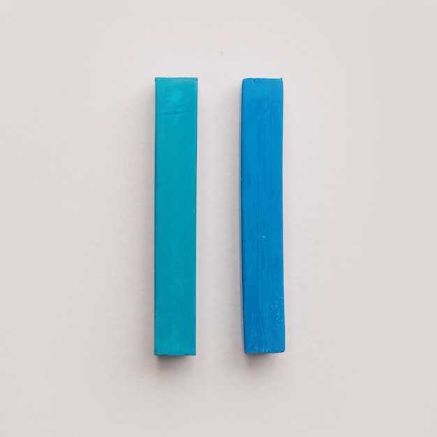 Dos piezas de tizas de crayón azul pastel
