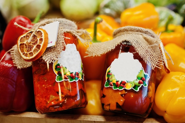 Dos pimientos dulces asados en escabeche en tarros en la estantería de un supermercado o tienda de comestibles