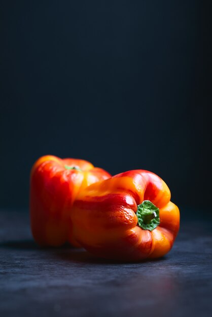 dos pimientos rojos sobre una superficie negra