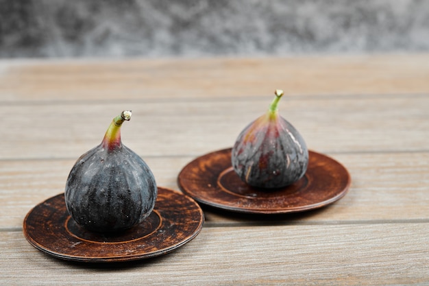 Foto gratuita dos platos de higos sobre mesa de madera.