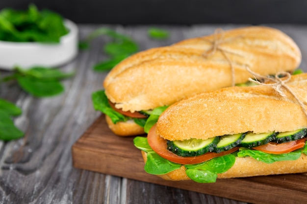 Dos sándwiches con rodajas de espinacas y pepino.