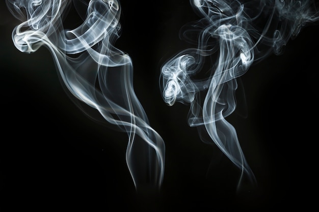 Dos siluetas de humo sobre fondo oscuro