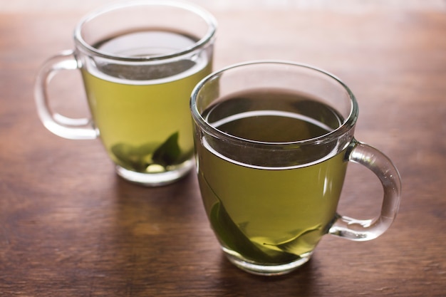 Foto gratuita dos taza de té de hierbas en la mesa de madera