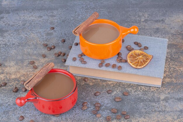 Dos tazas de café, libros y granos de café en la mesa de piedra. Foto de alta calidad