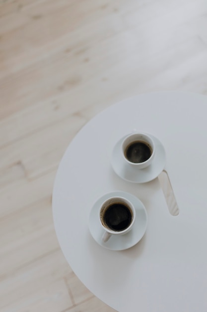 Foto gratuita dos tazas de café en una mesa blanca