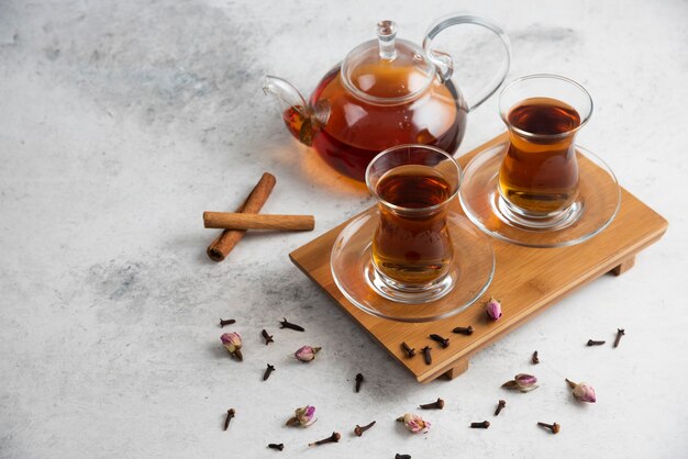 Dos tazas de té con canela y rosas secas.