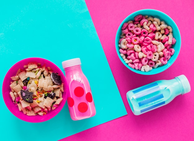 Dos tazones de cereales con botellas de leche.