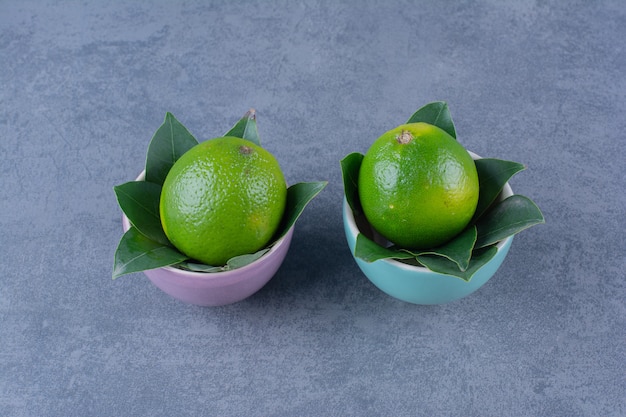 Dos tazones de limones, sobre la superficie oscura