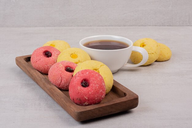 Dos tipos de galletas y taza de té en blanco.