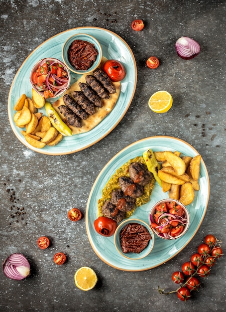 Dos tipos de platos principales con papas en la mesa