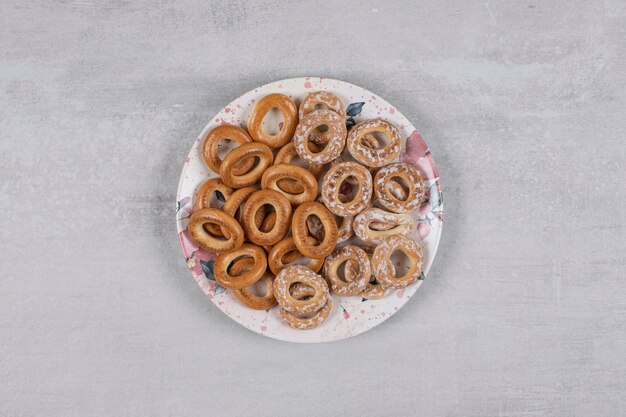 Dos tipos de sabrosos anillos de pretzel en plato blanco.