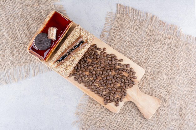 Dos tortas y granos de café sobre tabla de madera. Foto de alta calidad