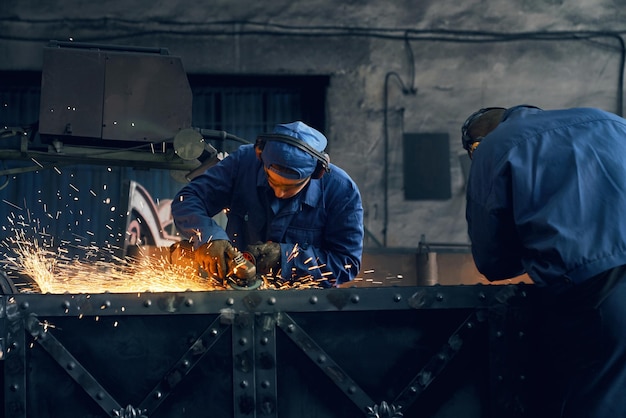 Dos trabajadores haciendo puertas en herrería