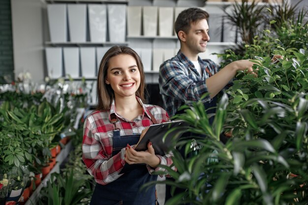 Dos trabajadores con ropas especiales que trabajan en el centro de jardinería