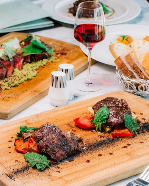 Dos trozos de bistec cocido medio servido con champiñones tomate y calabacín