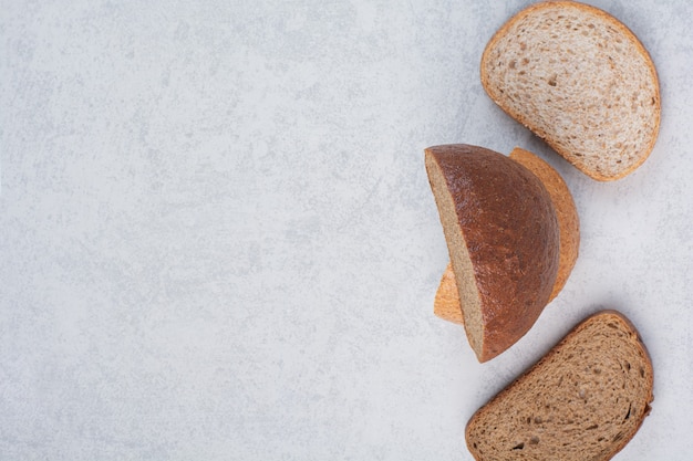 Dos variedad de rebanadas de pan sobre la superficie de piedra