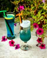 Foto gratuita dos vasos de bebidas azules con tubos de paja de plástico.