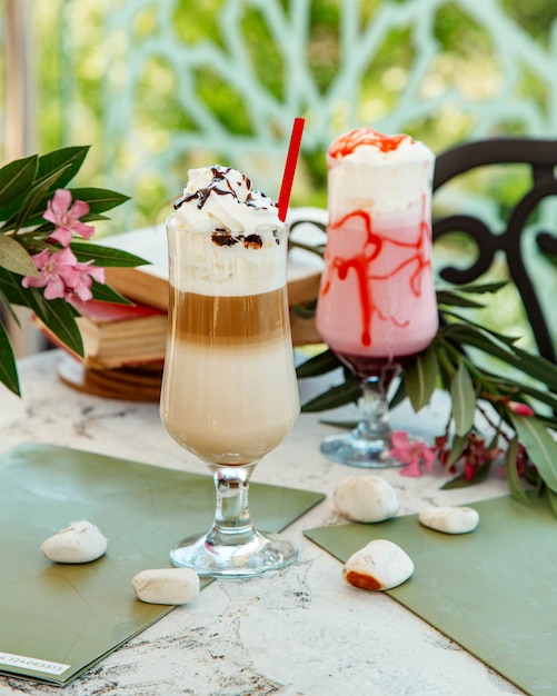 Dos vasos de café con leche y cóctel de fresas