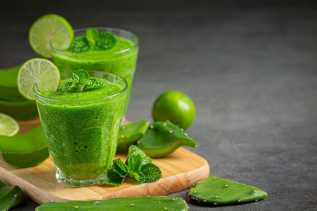 Dos vasos de jugo de aloe vera en tabla de cortar de madera