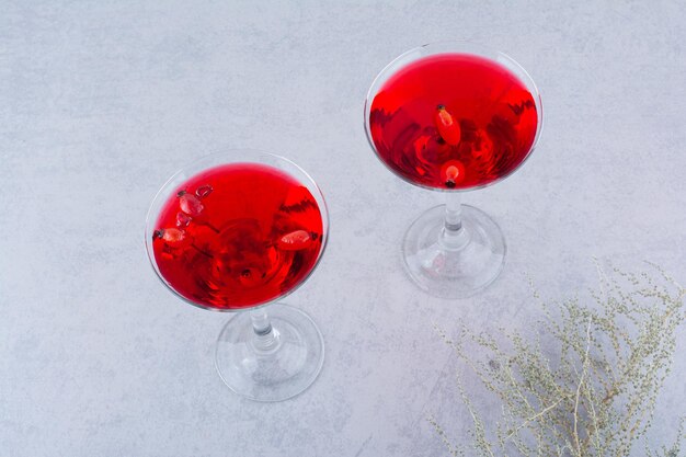 Dos vasos de jugo rojo sobre fondo de piedra. Foto de alta calidad