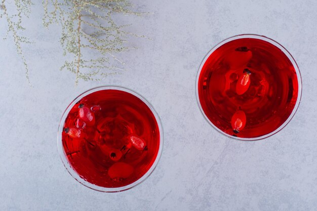 Dos vasos de jugo rojo sobre piedra