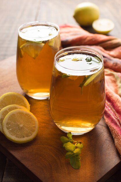 Dos vasos de té de limón y jengibre en mesa de madera