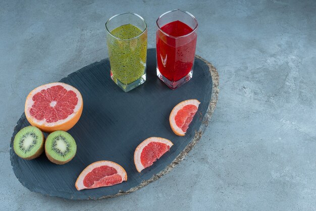 Dos vasos de zumos naturales con rodajas de diversas frutas.