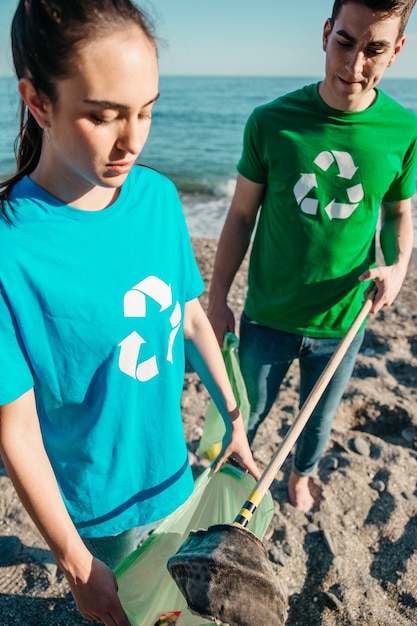 Dos voluntarios recogiendo basura en la playa