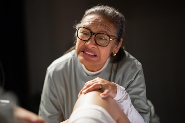 Doula asiática ayudando a una mujer a dar a luz. Mujer canosa de edad avanzada hablando con una paciente que da a luz. Concepto de parto en casa