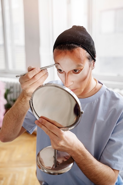 Foto gratuita drag queen poniéndose maquillaje en ángulo alto