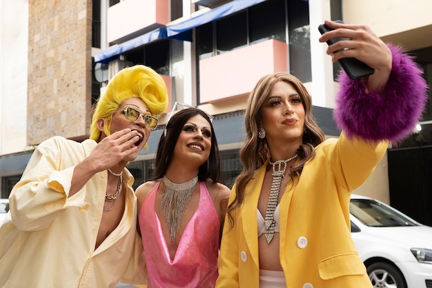 Drag queens de tiro medio tomándose una selfie