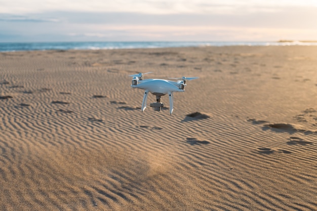 Drone aéreo volando bajo a tierra en la playa