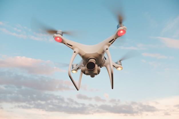 Drone blanco flotando en un cielo azul brillante