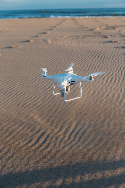 Drone privado aéreo aterriza en la arena de la playa